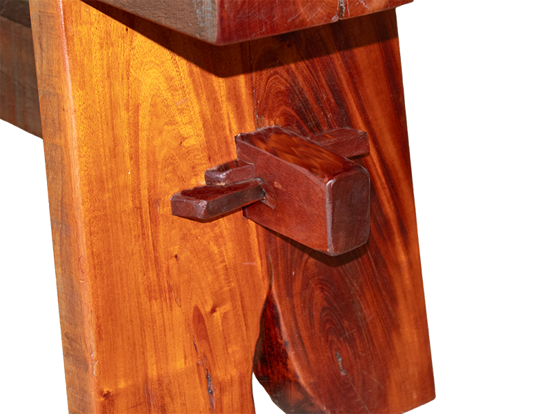 Mahogony split top bench using traditional joinery, with Maple and Purple Heart bowtie inlays, close up end view of leg and  pnned stretcher.